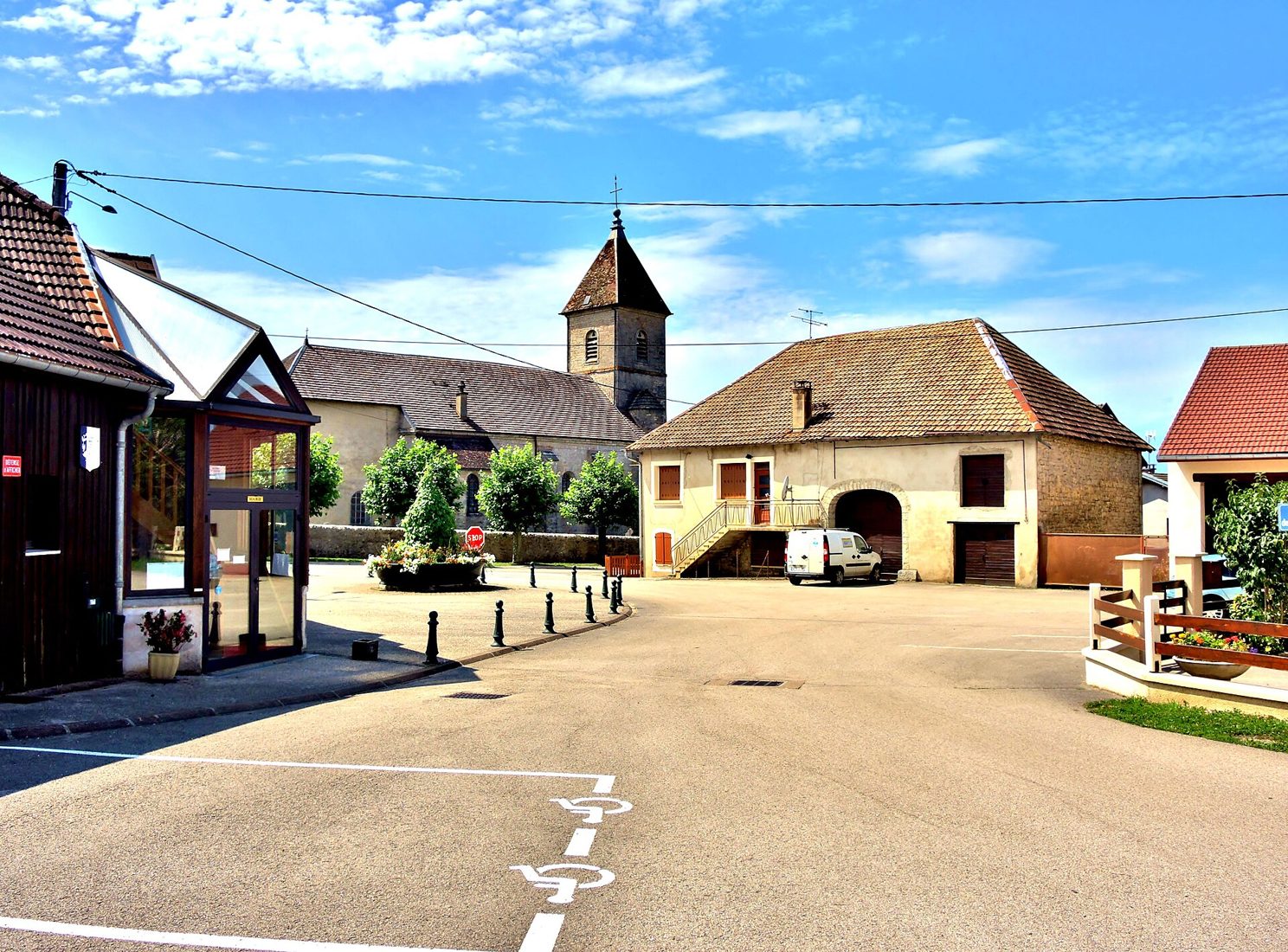 Place centrale d’un village français avec église et maisons en pierre