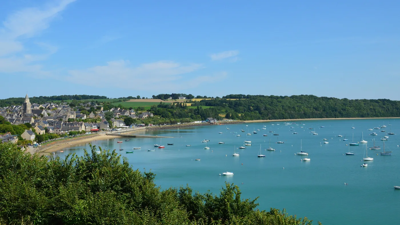 Village breton au bord de l’eau avec des bateaux dans un port calme.