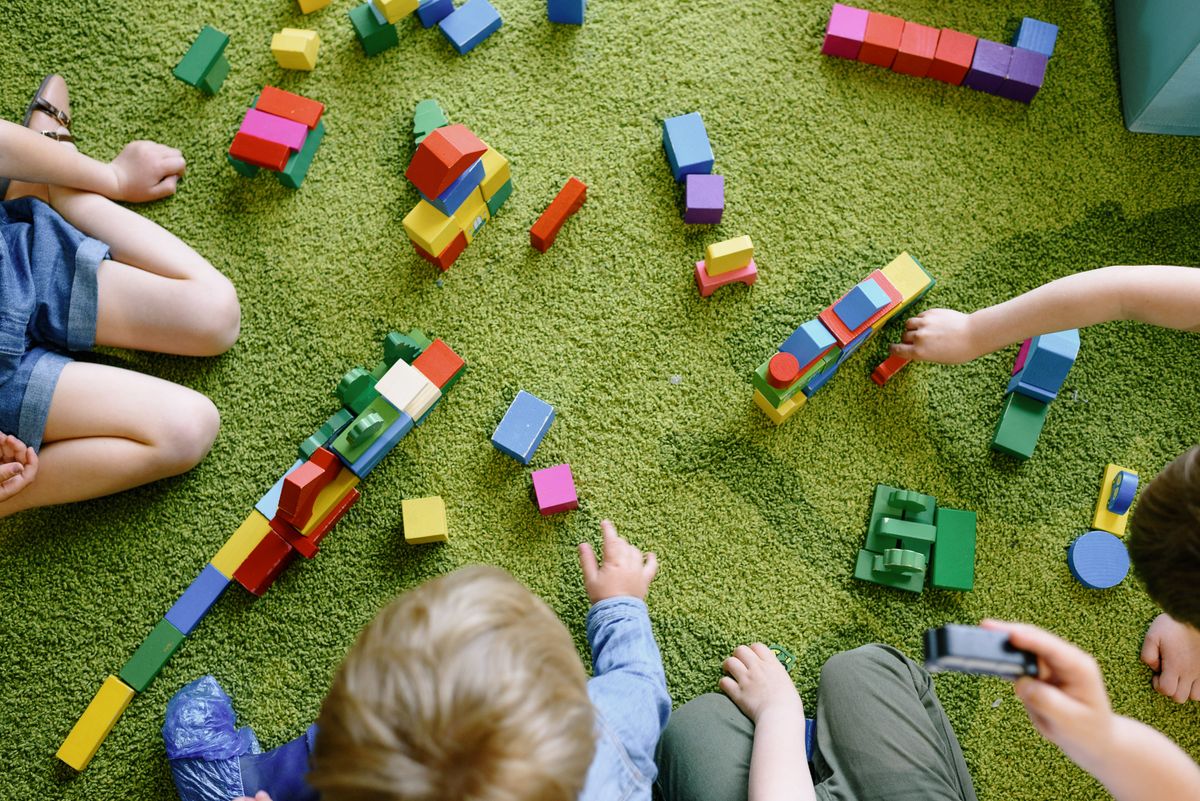 Des enfants jouent avec des blocs colorés ; illustration du jeu, sans attribution de milieu social.